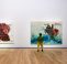 Two people stood in a gallery looking at two large artworks displayed on a white wall by artist Firelei Báez.