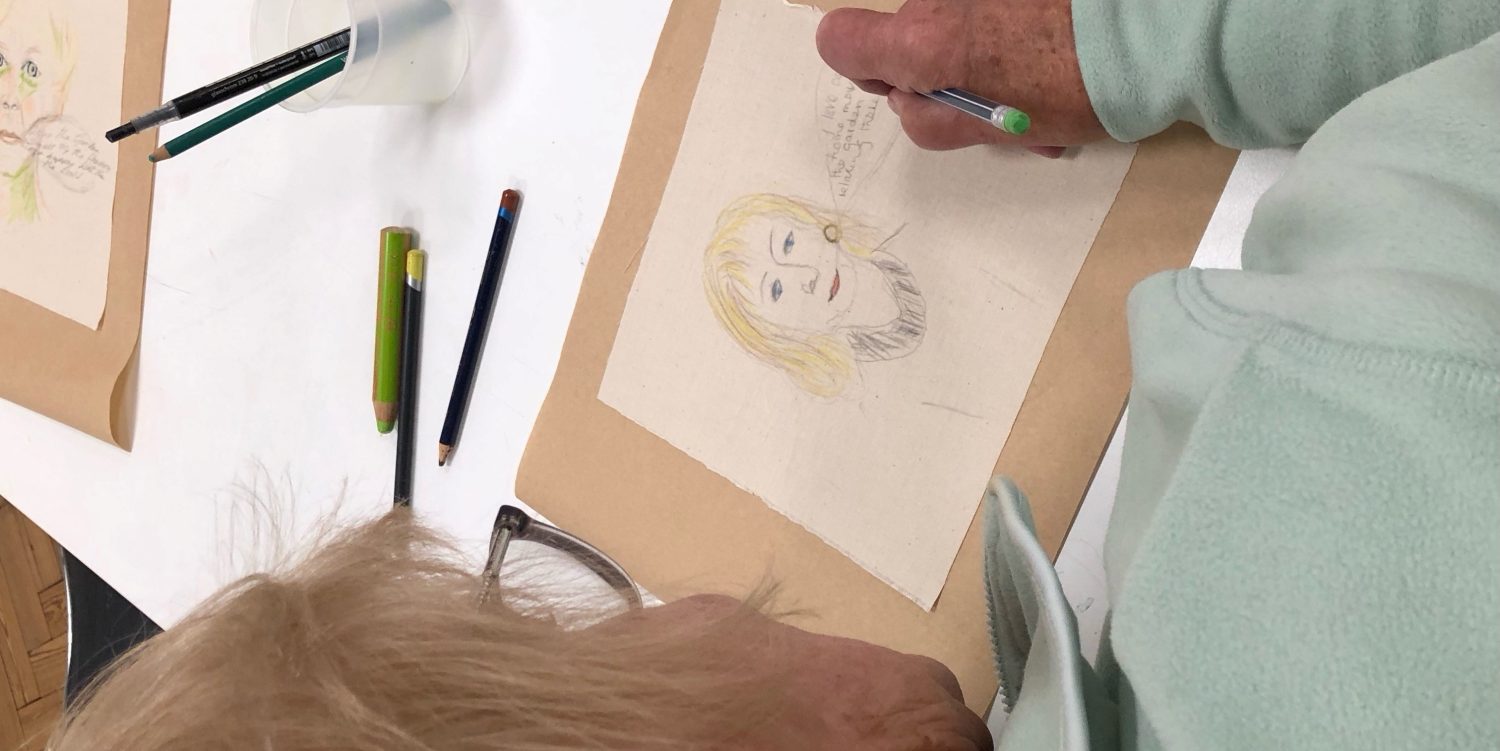 An elderly person is writing text in a speech bubble coming from an illustration of a woman.